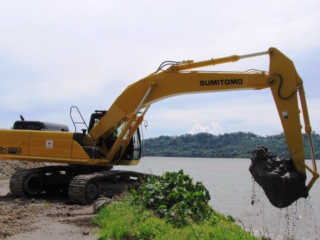 Excavator scooping dead coral from the sea