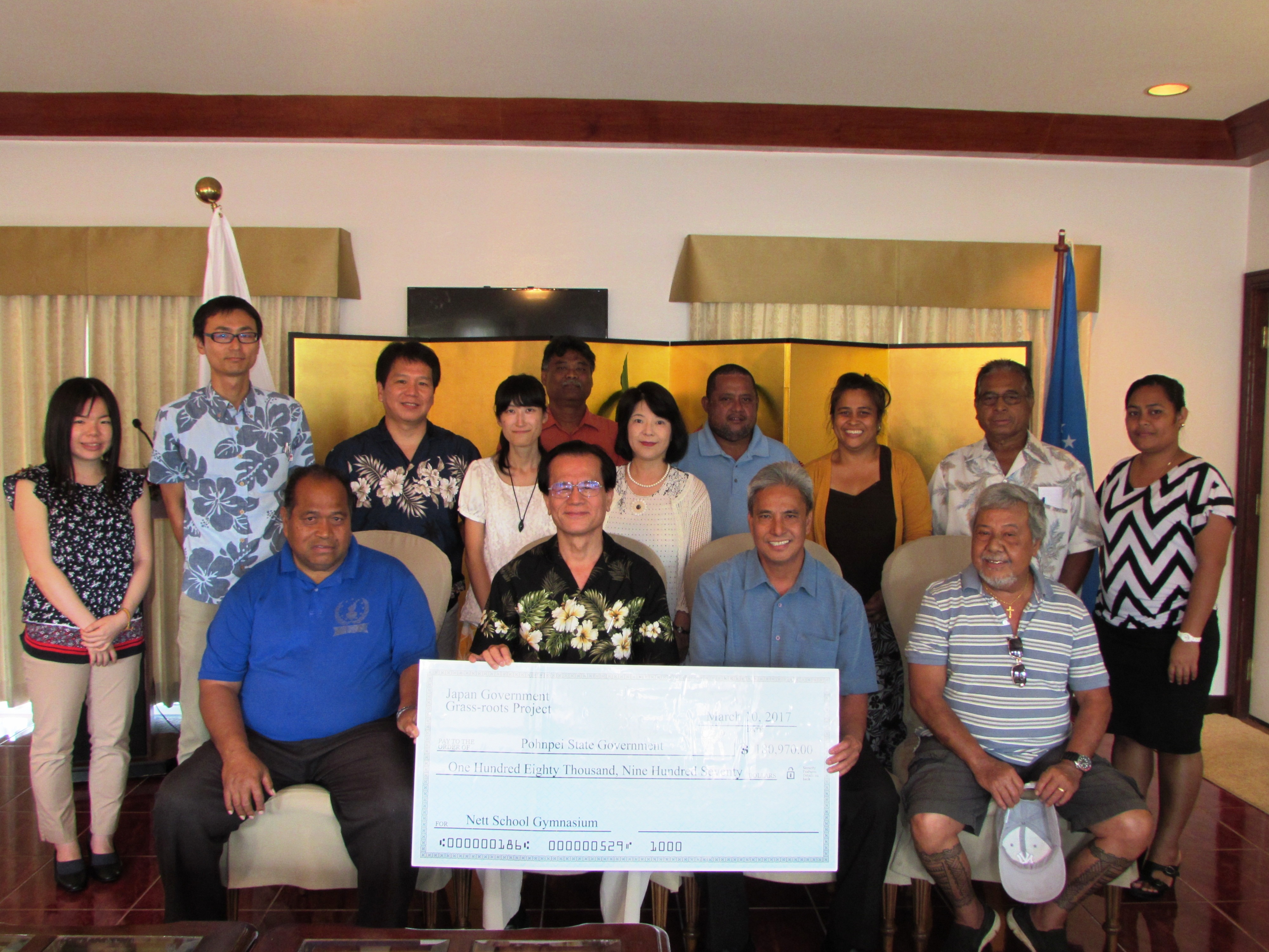 Group photo of the participants with the big check