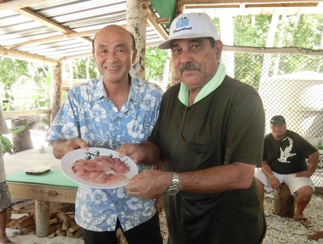 Ambassador Sakai and President Christian holding a plate of sashimi